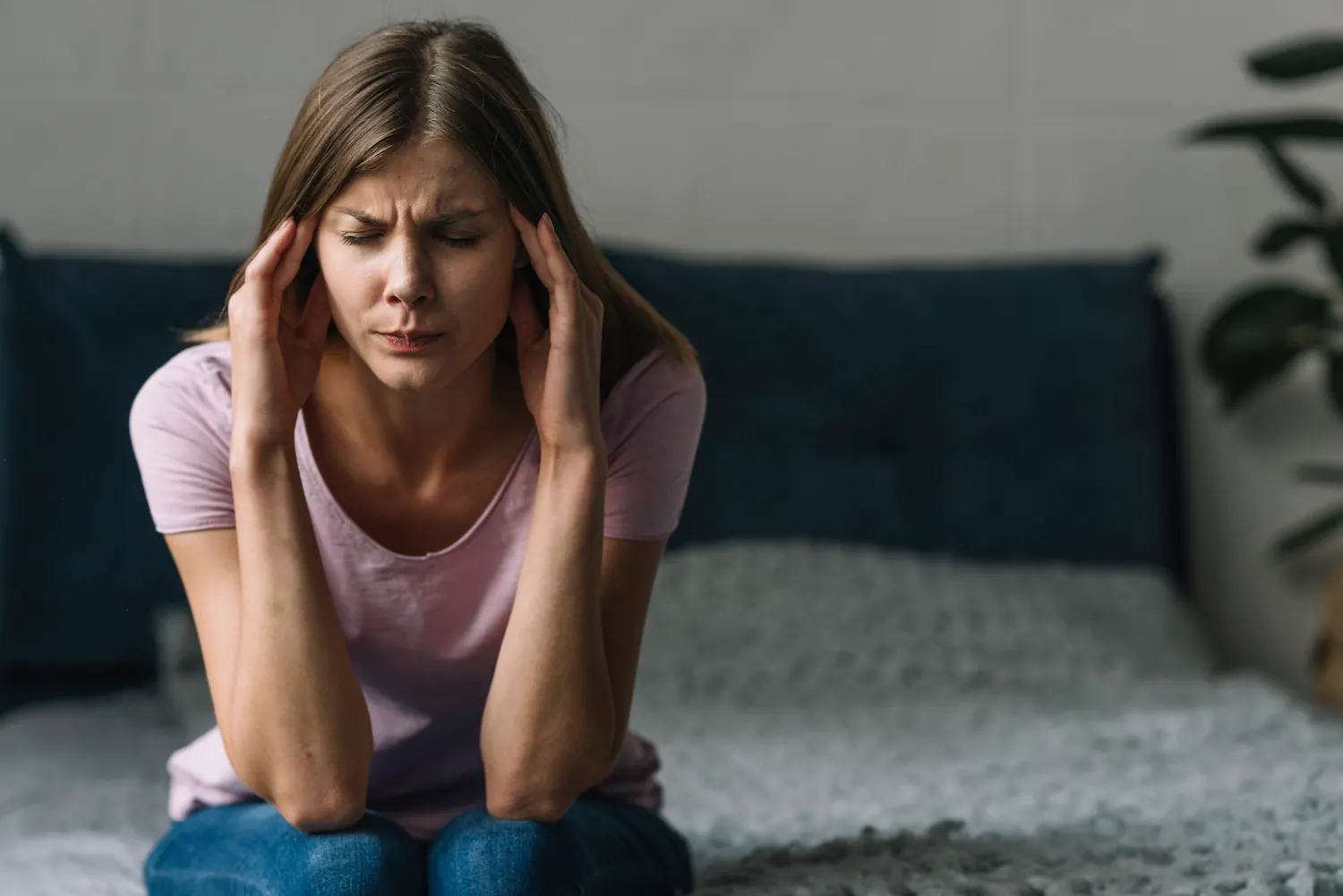 woman sitting in bed suffer from severe migraine
