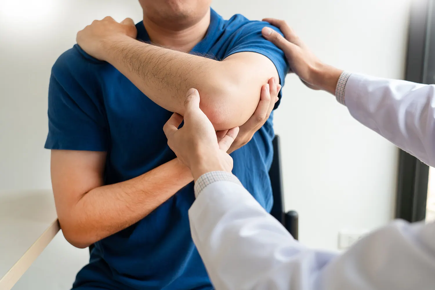 Chiropractor examining a patient’s shoulder