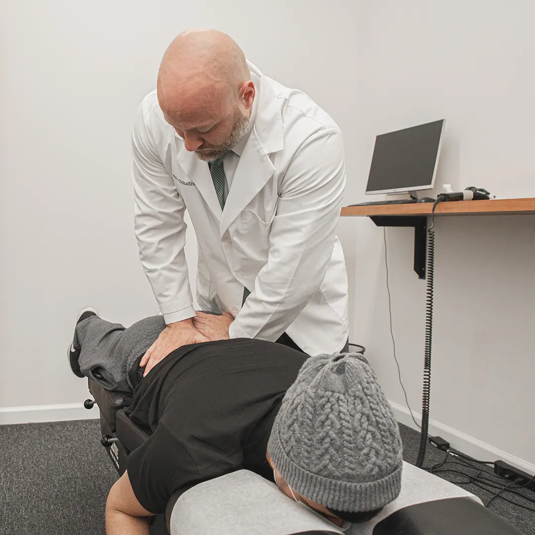 Dr. Eric Chludzinski doing spinal adjustment on patient