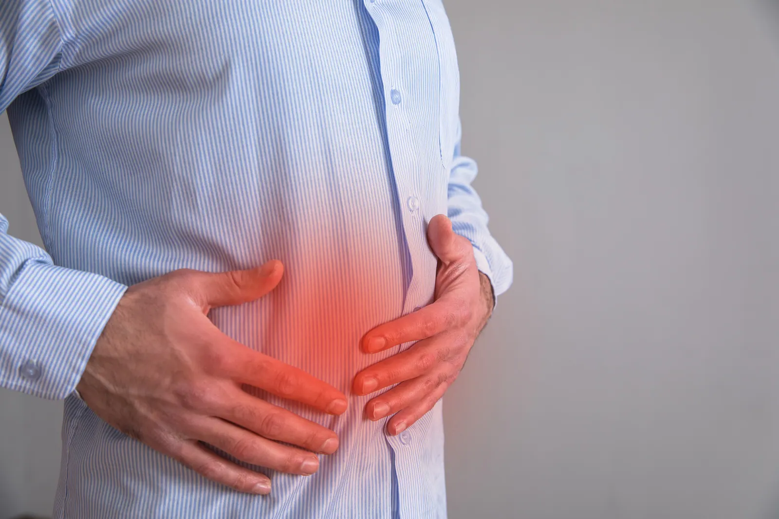 Man in a striped shirt with stomach pain
