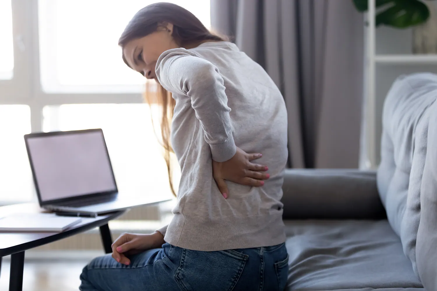 Young woman experiencing slipped disc pain